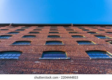 The Wall Of The Historical Building Of The Cotton Factory With The Clock Tower In The Old Industrial Park On The River Nashua, View From The Bottom Up