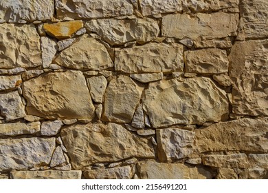 wall of the house with perfectly inlaid pieces of building marl stone in sunny weather - Shutterstock ID 2156491201