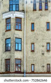 The wall of the house with windows of different sizes and shapes