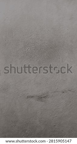 A wall with layers of paint and small splotches that create a distressed texture
