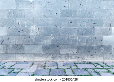 The wall with light gray, white bricks and cobblestone sidewalk decoration for background.