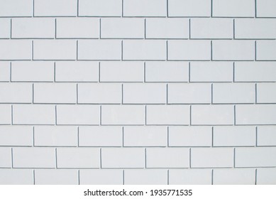 the wall is made of bricks covered with gray paint and plaster