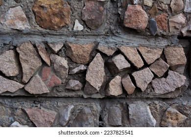 Wall made of pieces of broken stones. Artificial marble for exterior decoration. Background for the site of a hardware store. Texture of solid stone, rocks. The concept of impenetrability, fortitude - Shutterstock ID 2237825541