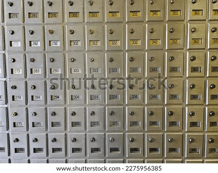 A wall of mail boxes inside of a post office.