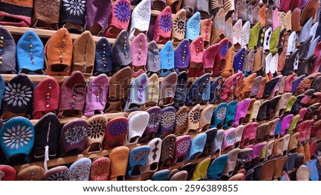 Wall of a market shop in Marrakech, covered with various types of shoes in typical Moroccan style.