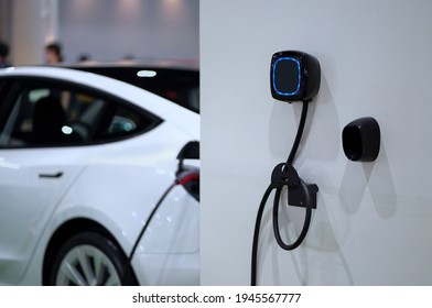 Wall mounted electric charger in the home garage.