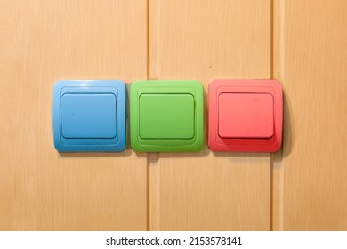Wall mounted electrical rocker light switch. A colour old toggle light switch on a  yellow wooden wall. Turn-on turn-off