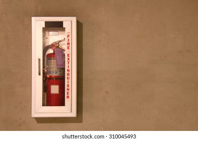 A Wall Mounted Fire Extinguisher In An Easily Accessible Glass Case.