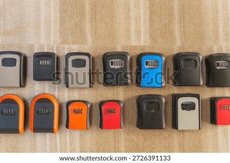 Wall mounted key lockboxes in various colors and designs on wooden surface