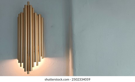 A wall mounted light fixture with gold colored rods - Powered by Shutterstock