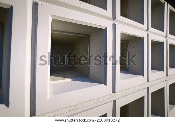 Wall with new empty cremation niches.\
Row with empty graves for cinerary urns. Cremation service,\
cemetery property. Columbarium area outside\
crematorium