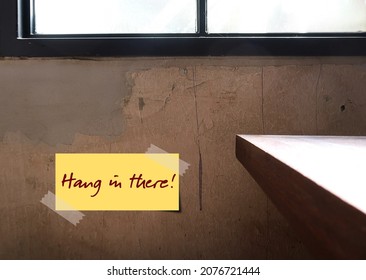 Wall With Note Written HANG IN THERE, Positive Self Reminder To Remain Persistent And Determined In Difficult Circumstances, Encouragement Note Telling Someone To Not Give Up, Despite Difficulties