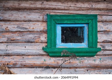 A wall of old logs with a window.