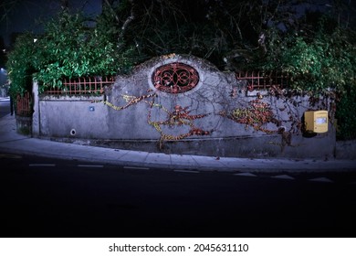 A Wall On A Sloping Street With A Metal Inlay And A Yellow Post Box