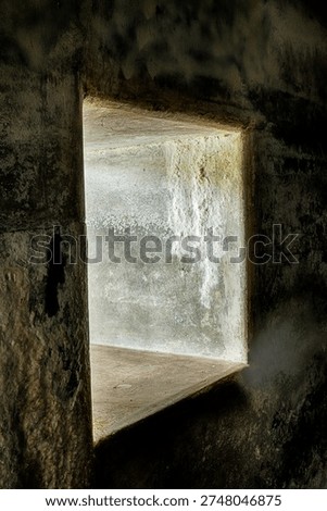 A wall opening lets in light to some of the underground rooms through the thick concrete walls at Fort Casey.