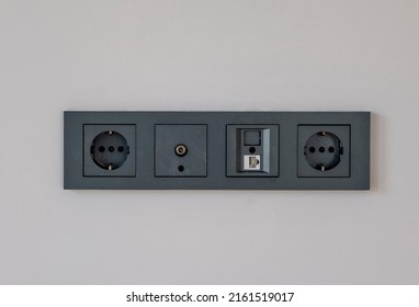 Wall Outlet With Different Sockets. Multi Panel, Internet, Tv Or Radio Adapter Socket In Smoked Color On Champagne Color Wall Background At Home