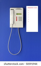 Wall Phone On A Blue Background And List Of Numbers