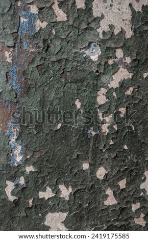 Wall with pieces of old dark green paint, large angle with cracks, scuffs, vertical orientation