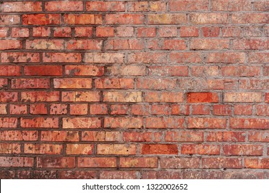 The wall is of red brick with natural defects: faults, cracks, chips, scratches, crevasses, roughness. Horizontal masonry. Part of the old wall. Could be used as background for design. - Shutterstock ID 1322002652