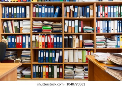 Wall from shelves with colourful file binders, interior of an office room with papers and documents - Powered by Shutterstock