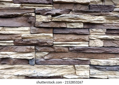 Wall stonework finishing from colorful natural stone trim as background front view close up