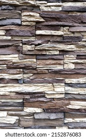 Wall stonework finishing from colorful natural stone trim as background front view vertical close up