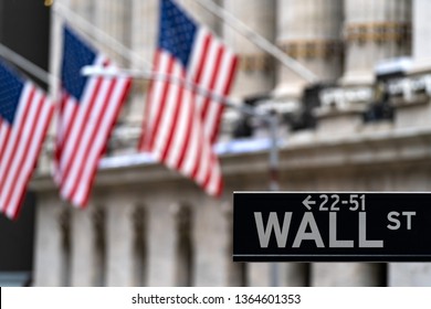 Wall street sign with New York Stock Exchange background New York City, New York, USA.