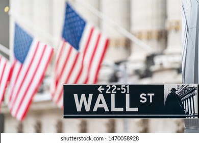 Wall Street Sign In New York City Financial Economy And Business District With America National Flag Background. Stock Market Trade And Exchange Zone.