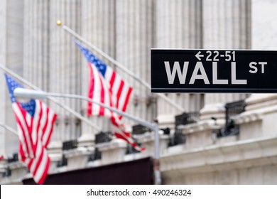 Wall street sign with the New York Stock Exchange and american flags on the background