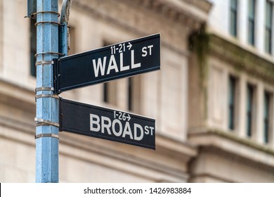 Wall Street "WALL ST" sign and broadway street over  NYSE stock market exchange building background. The New York Stock Exchange locate in economy district, Business and sing of landmark concept