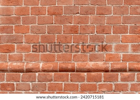 Wall texture with red bricks, geometric background with horizontal row of protruding, round red bricks, Background with copy space 