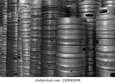 Wall of used and scratched stainless steel beer barrels or kegs. Stacked in a row large silver or metallic colour alcohol barrels or containers. Old Aluminum Beer keg.
