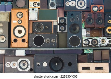 Wall of various old, colorful stereo speakers stacked on top of each other.