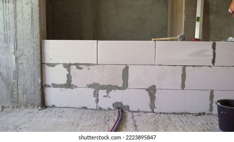 Wall of white blocks in a new apartment. Interior of an unfinished building. Construction of gas blocks and internal partitions between rooms. - Shutterstock ID 2223895847