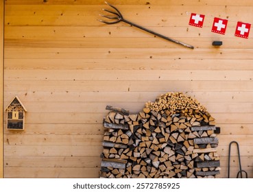 Wall wooden chalets adorned with decorative wooden pitchfork, a pile of firewood and flags of Switzerland.