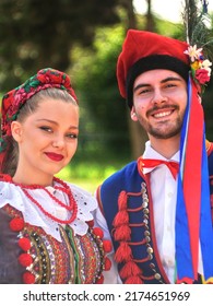 Wallers, France - 07 02 2022 : Close-up Portrait Of A Couple Of Polish Dancers In Traditional Dress. Their Clothes Are Colorful, They Are Smiling And Happy. A Blurred Background Enhances The Colors.