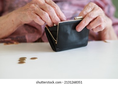 A wallet in the hands of an old woman, a grandmother puts and counts coins in her empty leather wallet, poverty and misery of the older generation, wrinkled hands close-up.
 - Shutterstock ID 2131268351