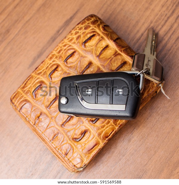 Wallet and key fob\
by car on a wooden table
