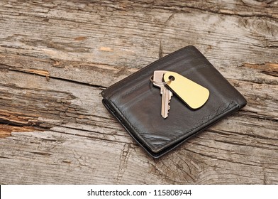 wallet and key on wood background