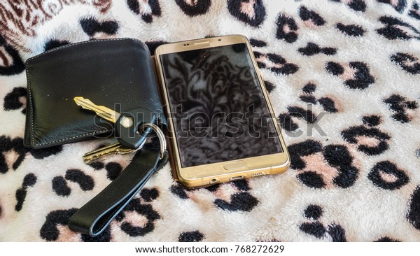 wallet\
key smart phone on cotton paint platern\
background