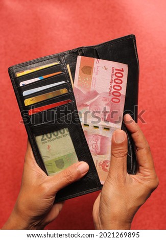 wallet and rupiah money in women's hands