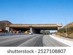 Wallis Annenberg Wildlife Crossing at Liberty Canyon, bridge crossing under construction over the 101 freeway, highway. Santa Monica mountains in background