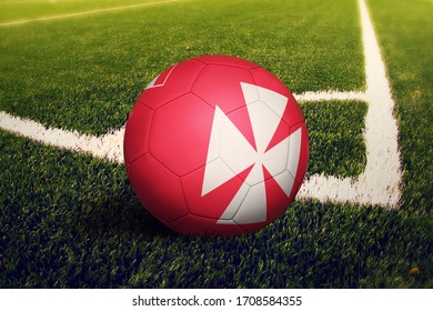 Wallis And Futuna flag on ball at corner kick position, soccer field background. National football theme on green grass. - Powered by Shutterstock