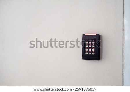 A wall-mounted access control system featuring a keypad designed for secure entry. Ideal for enhancing safety in various environments such as offices or homes.