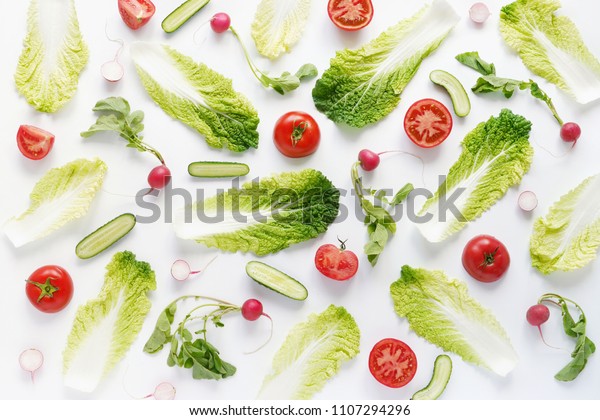 Wallpaper abstract composition of vegetables (tomatoes, Peking cabbage, radish, cucumbers). Food pattern vegetables. Healthy food concept. Vegetables isolated, flat lay, top view.