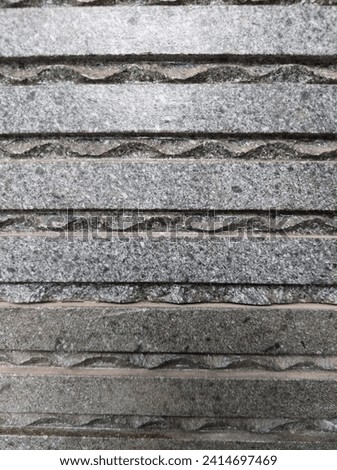 The walls are covered with textured gray patterned ceramics The walls are covered with textured gray patterned ceramics