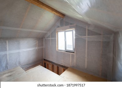 The walls of the frame house are sheathed with a vapor barrier membrane - Shutterstock ID 1871997517