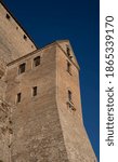 The walls of a medieval castle in the rays of the sun on a background of blue sky.