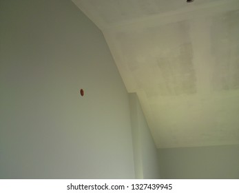 Walls painted in grey color, a suspended ceiling covered with an undercoat