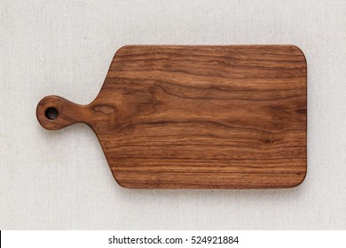 Walnut handmade wood cutting board on the linen